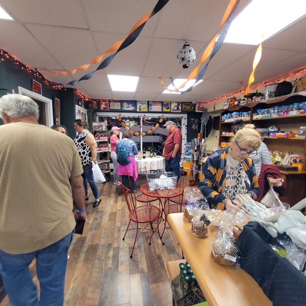 people milling around a shop decorated for halloween